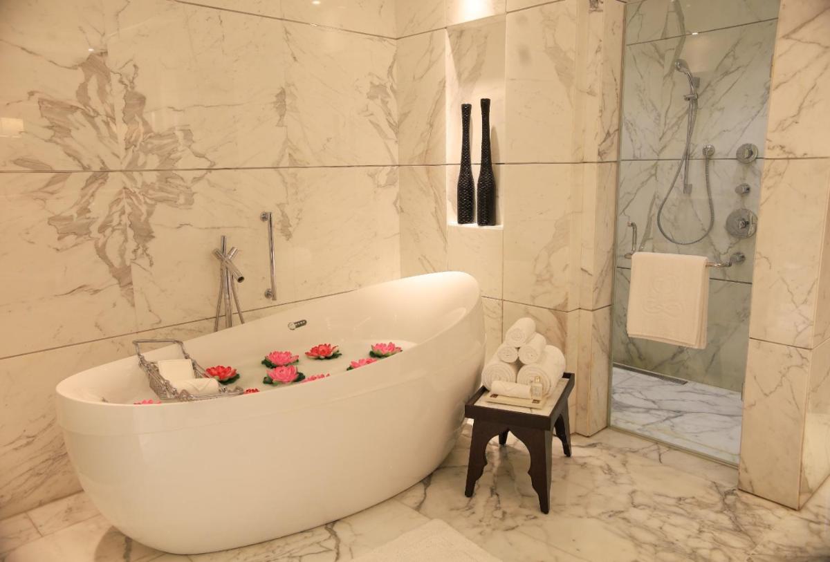 a bathroom with a bath tub with flowers on it at The Leela Ambience Convention Hotel Delhi in New Delhi