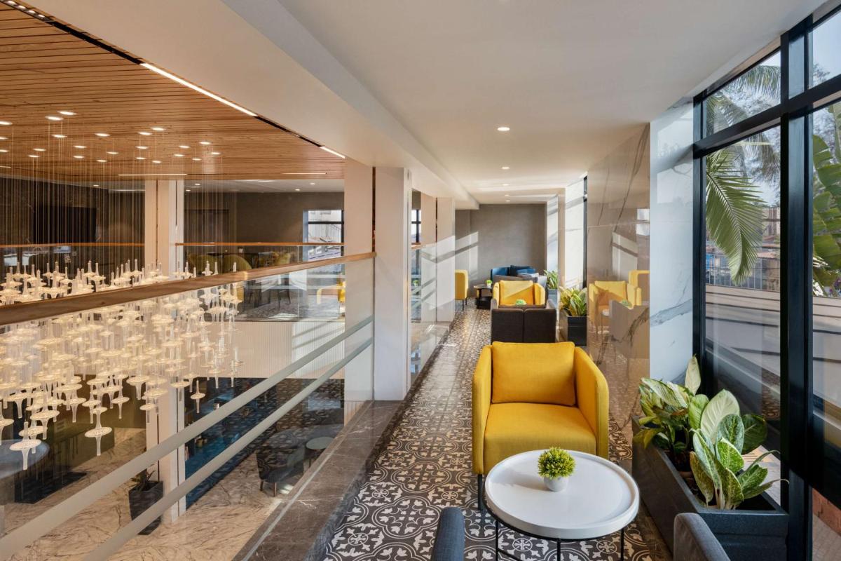 a lobby with a yellow chair and a table at Hyatt Place Goa Candolim in Candolim a lobby with a yellow chair and a table at Hyatt Place Goa Candolim in Candolim