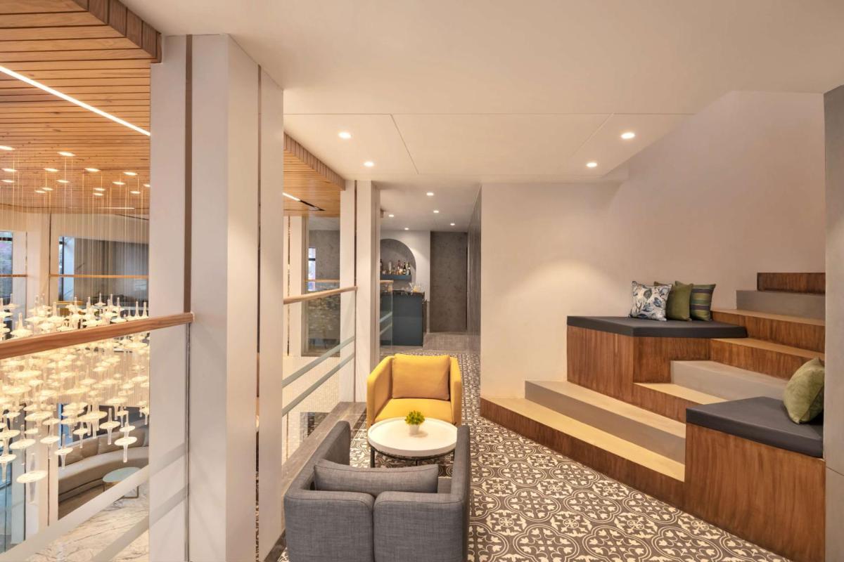 a room with a table and a chair and stairs at Hyatt Place Goa Candolim in Candolim a room with a table and a chair and stairs at Hyatt Place Goa Candolim in Candolim