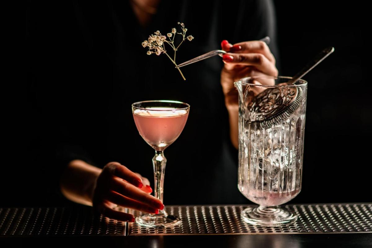 a woman is sitting at a table with a drink at JW Marriott Mumbai Juhu in Mumbai