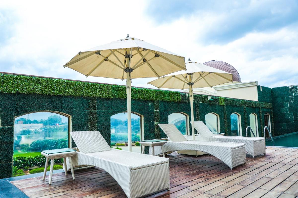 a group of chairs and umbrellas on a deck at Ramada Plaza by Wyndham Lucknow in Lucknow