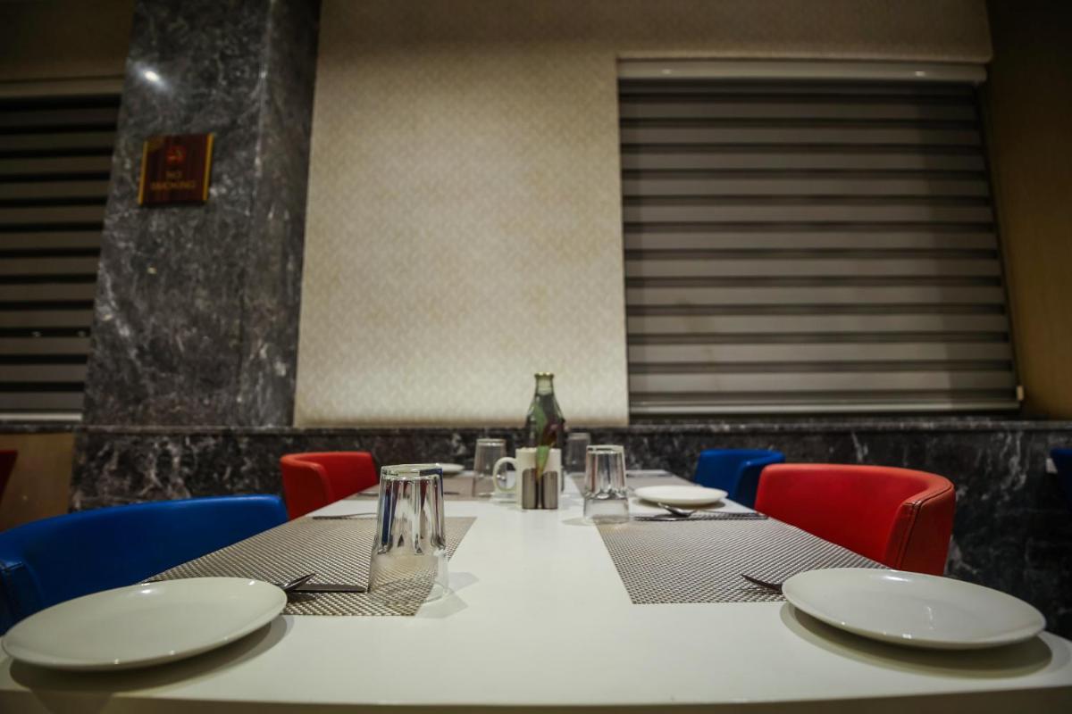 a table with chairs and a white table cloth at Ramada Plaza by Wyndham Lucknow in Lucknow