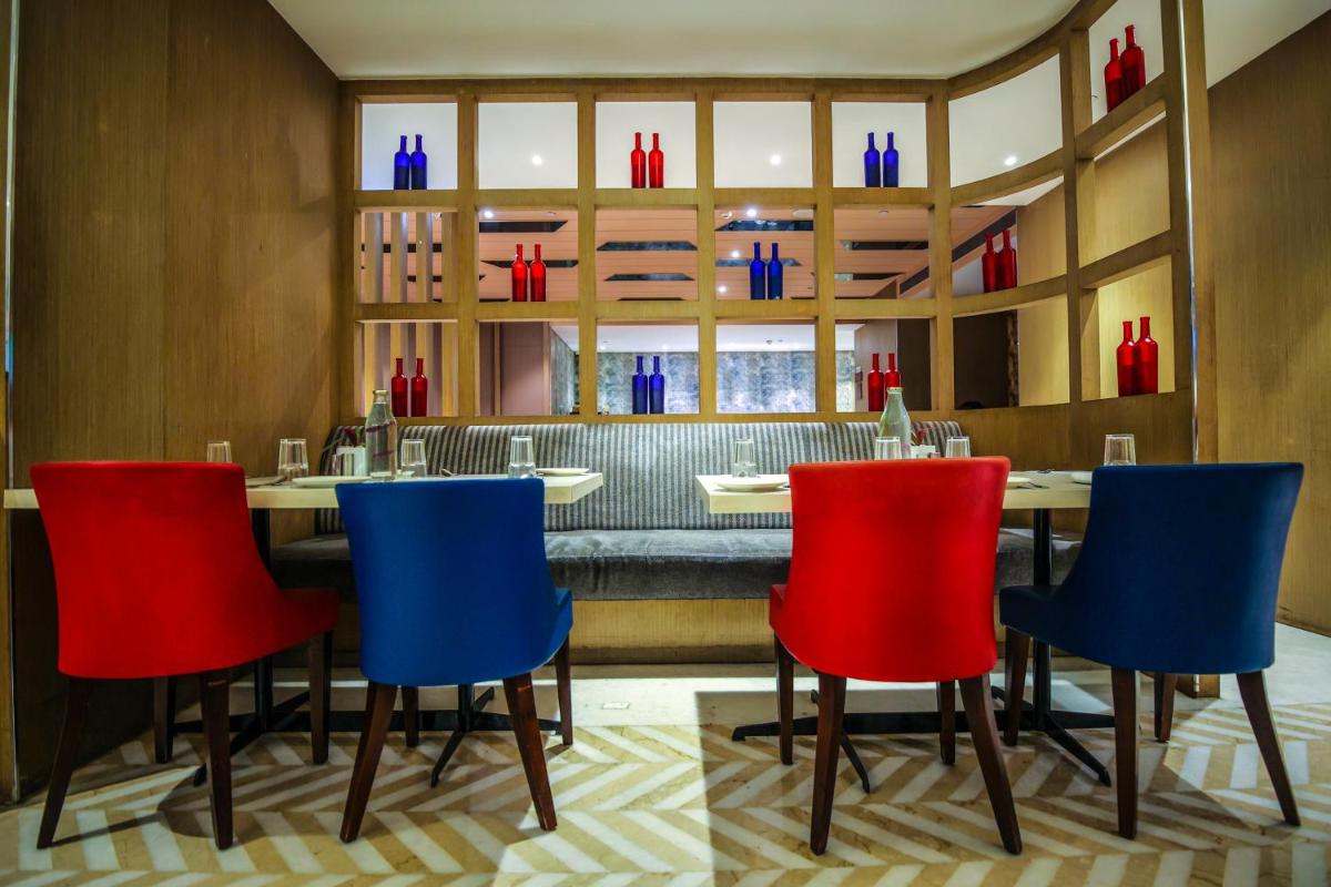 a dining room with a table and four chairs at Ramada Plaza by Wyndham Lucknow in Lucknow