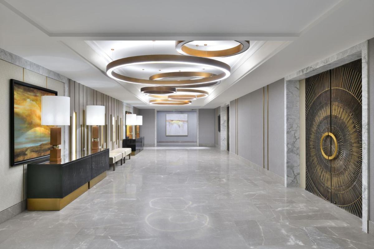 a hallway of a hotel with a lobby with couches and lights at The Westin Resort & Spa Himalayas in Rishīkesh