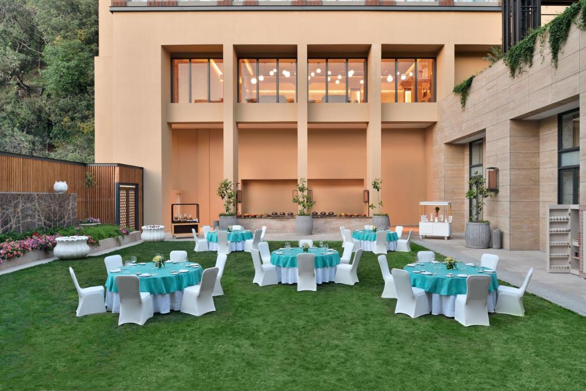 a group of tables and chairs on a lawn in front of a building at The Westin Resort & Spa Himalayas in Rishīkesh