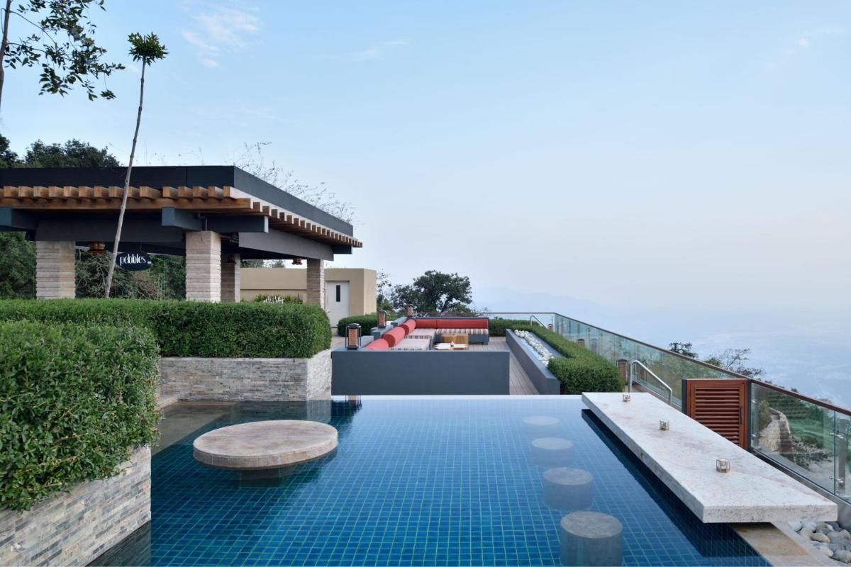 a swimming pool with a bench on the roof of a house at The Westin Resort & Spa Himalayas in Rishīkesh