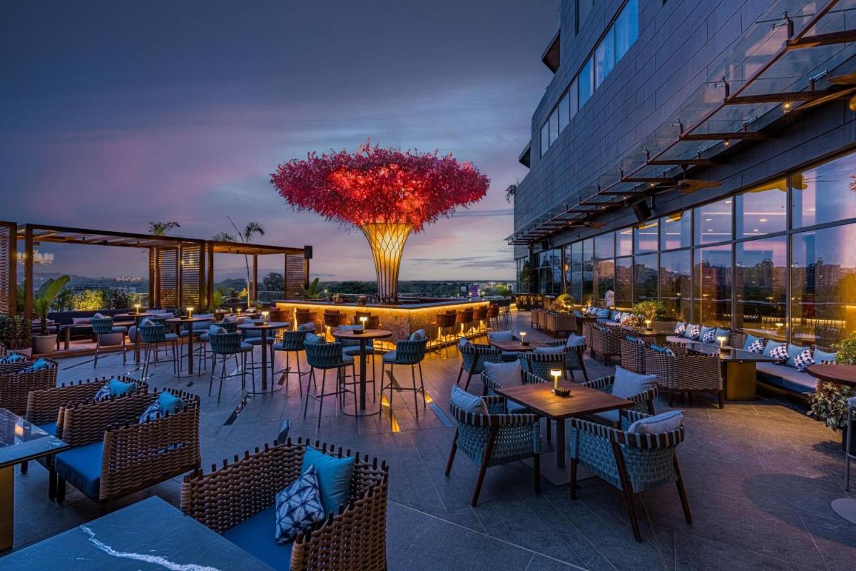 a restaurant with tables and chairs and a building at The Westin Pune Koregaon Park in Pune