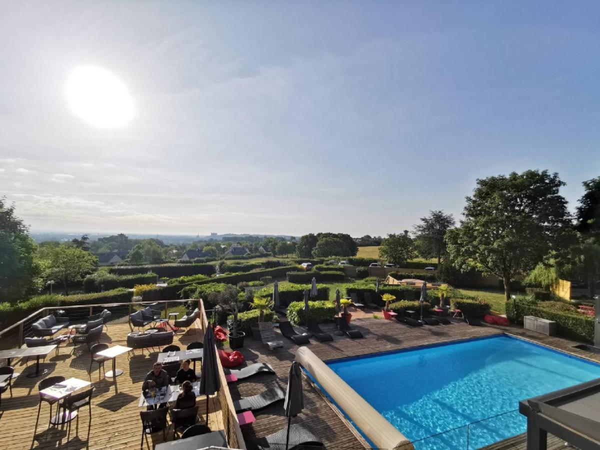 - une vue sur la piscine d'un hôtel avec des chaises et une piscine dans l'établissement Les Terrasses de Saumur - Hôtel & Appartements - Restaurant & Spa (Logis), à Saumur