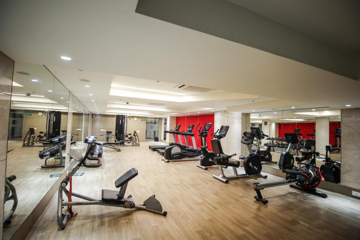 a gym with several treadmills and exercise bikes at Ramada Plaza by Wyndham Lucknow in Lucknow