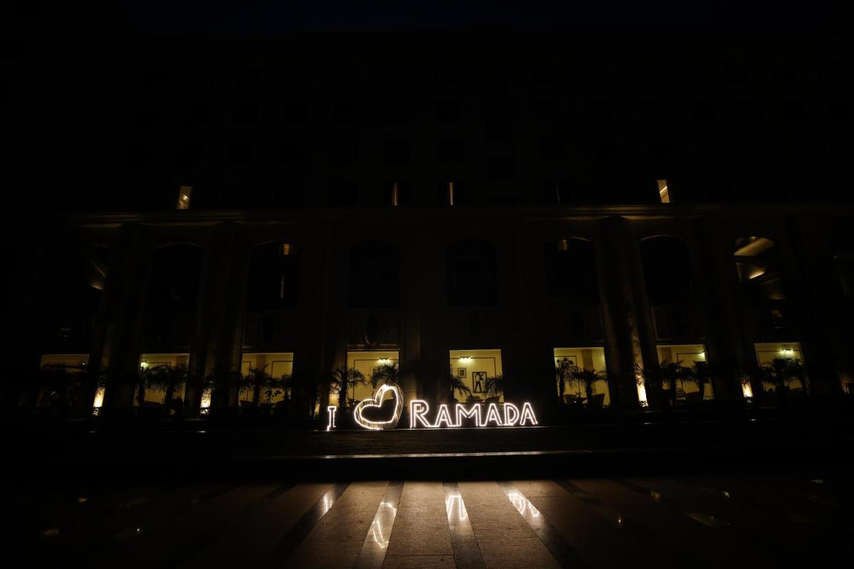 a sign on the side of a building at night at Ramada Plaza by Wyndham Lucknow in Lucknow