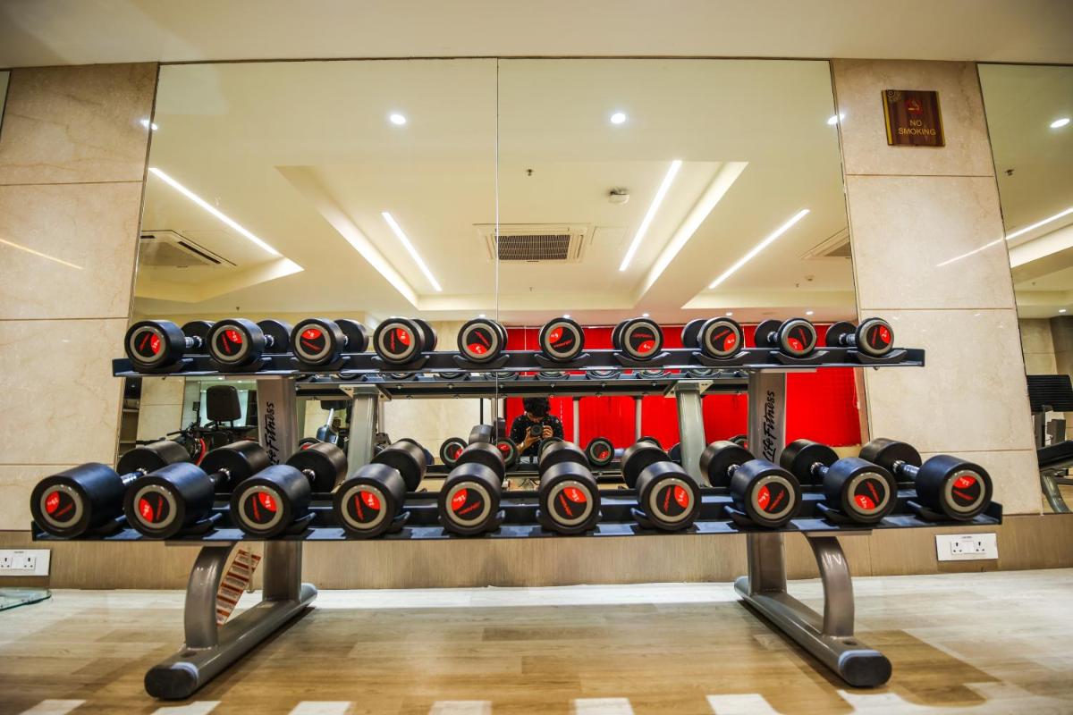 a gym with a rack of dumbbells at Ramada Plaza by Wyndham Lucknow in Lucknow