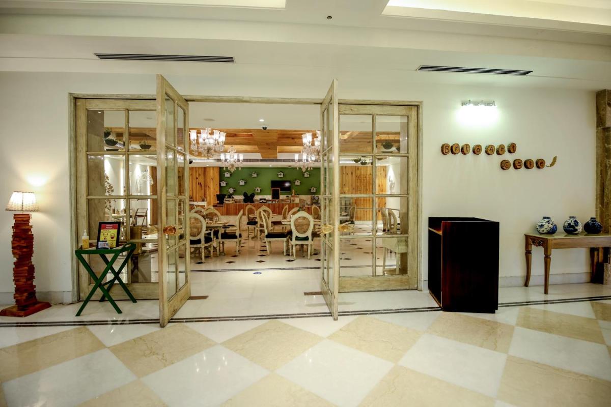 a room with glass doors and a dining room at Ramada Plaza by Wyndham Lucknow in Lucknow