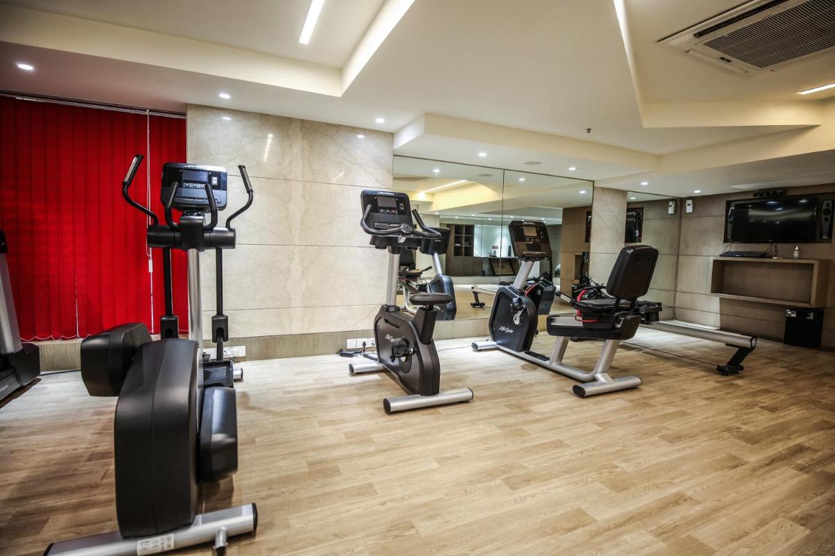 a gym with several treadmills and elliptical machines at Ramada Plaza by Wyndham Lucknow in Lucknow