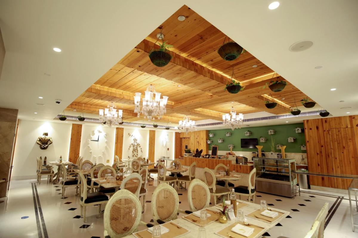 a restaurant with wooden ceilings and tables and chairs at Ramada Plaza by Wyndham Lucknow in Lucknow