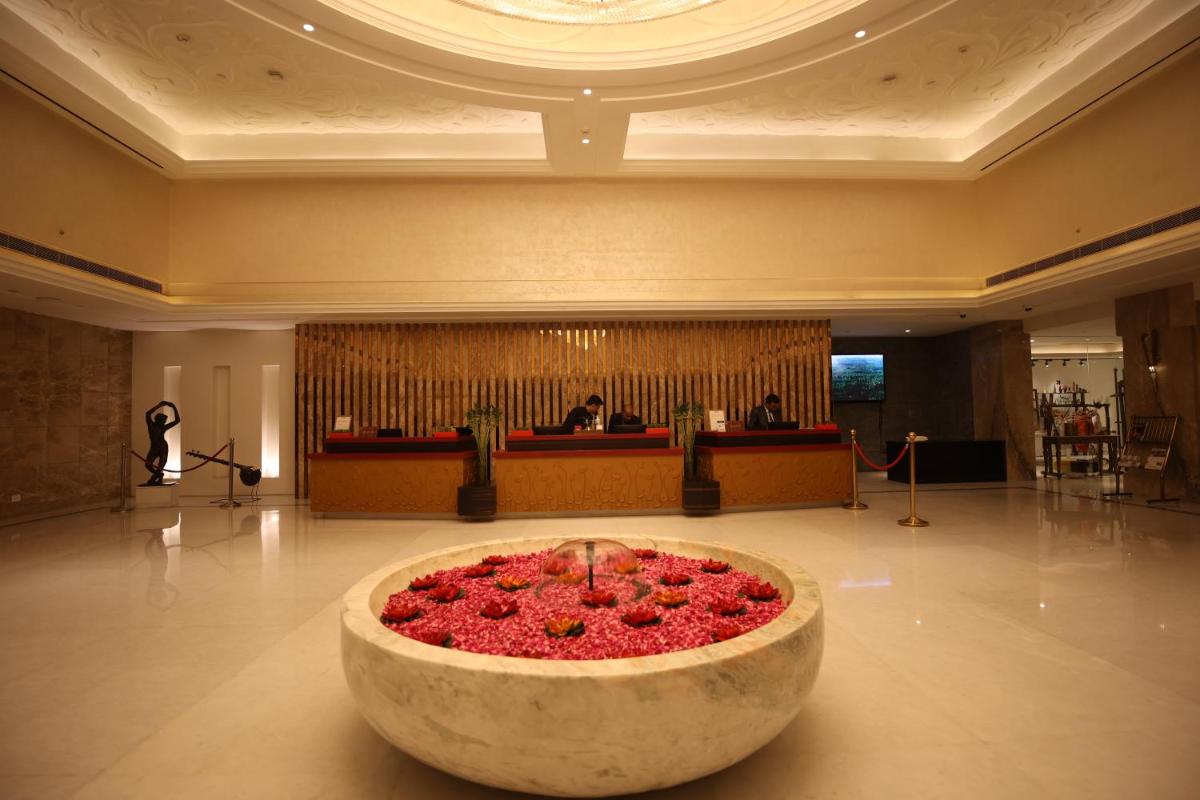 a lobby with a large bowl of flowers in the middle at Ramada Plaza by Wyndham Lucknow in Lucknow