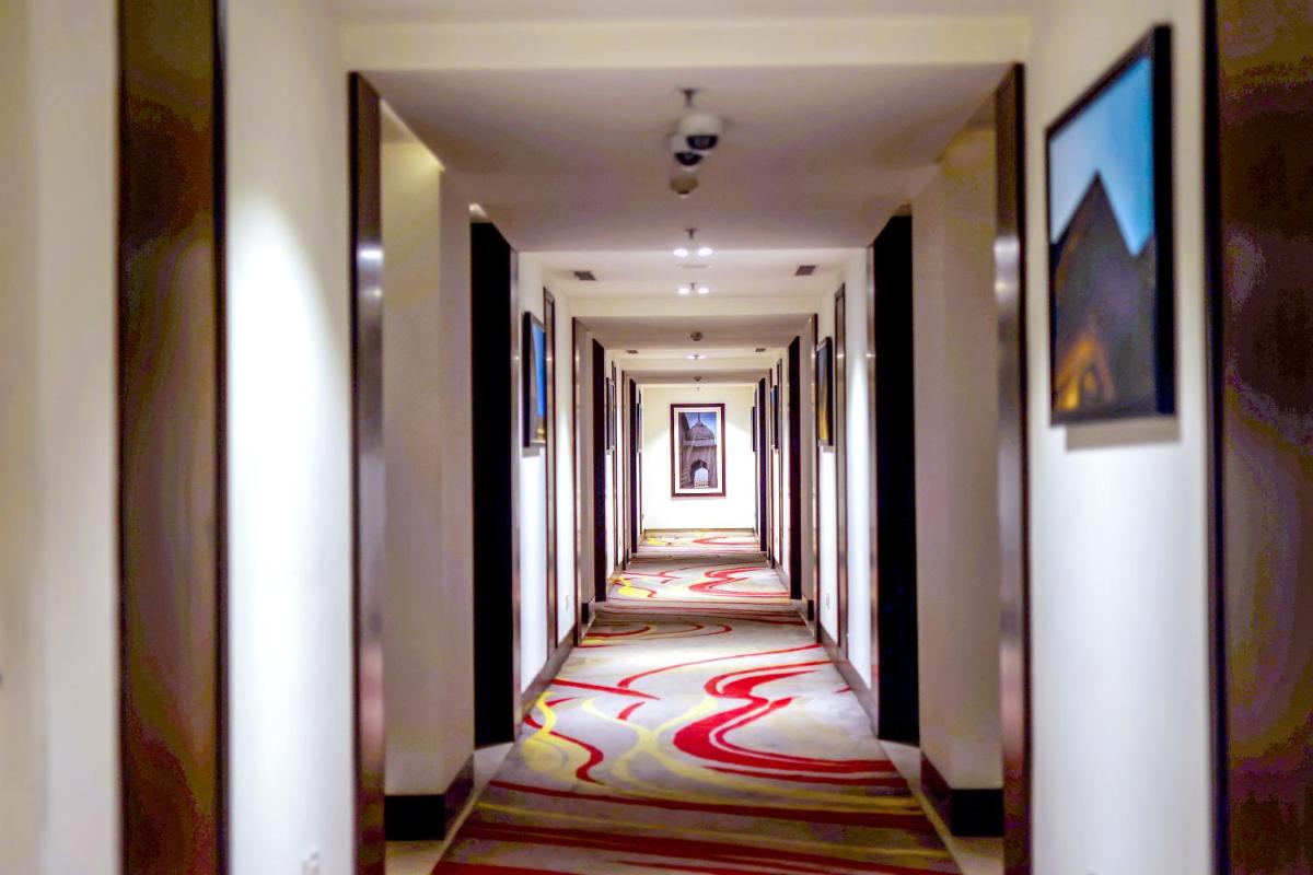 a corridor in a hotel with a carpet on the floor at Ramada Plaza by Wyndham Lucknow in Lucknow