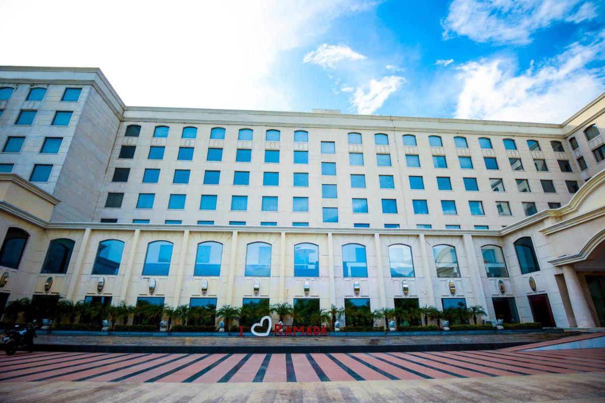 a large white building with blue windows at Ramada Plaza by Wyndham Lucknow in Lucknow