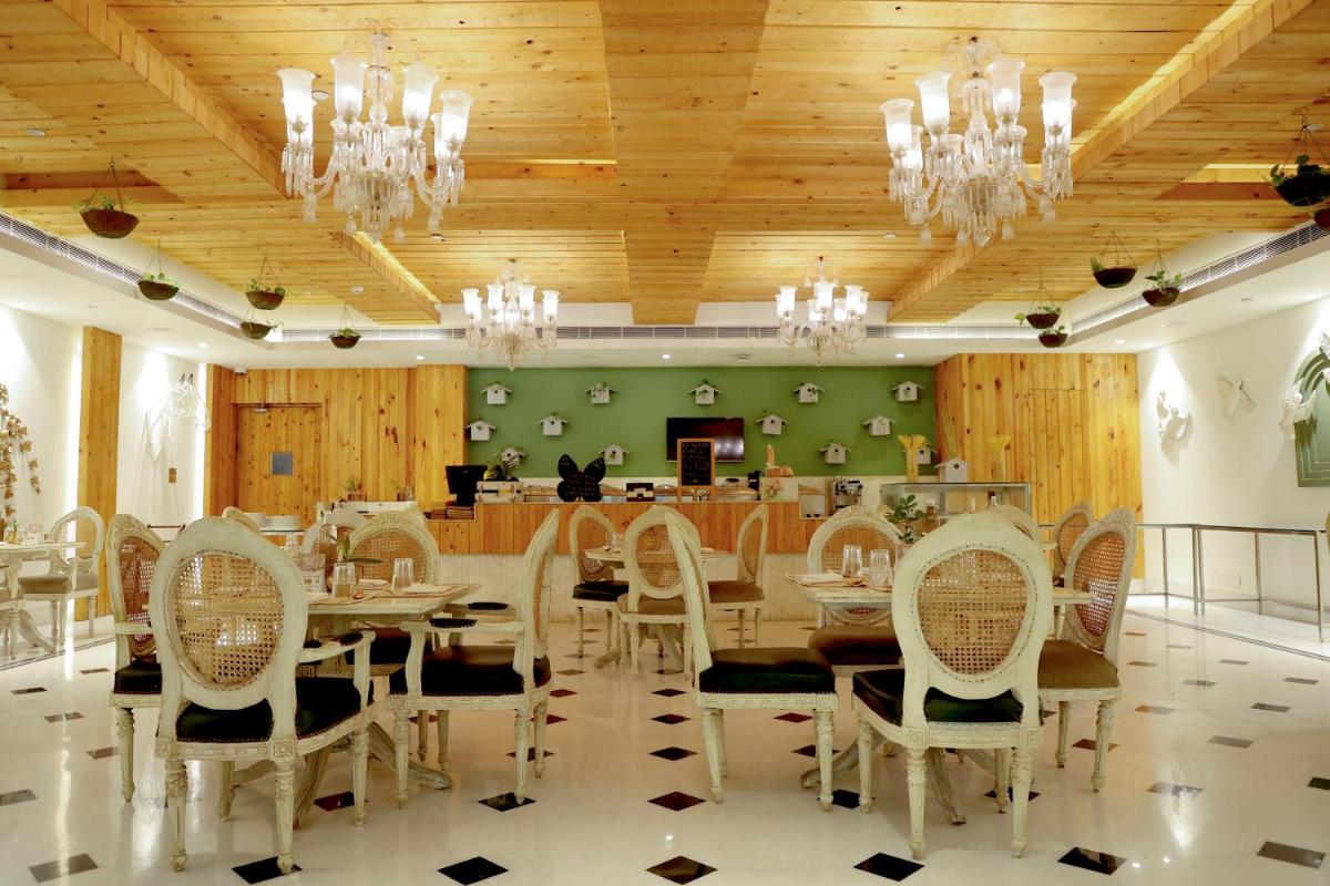 a dining room with a table and chairs at Ramada Plaza by Wyndham Lucknow in Lucknow