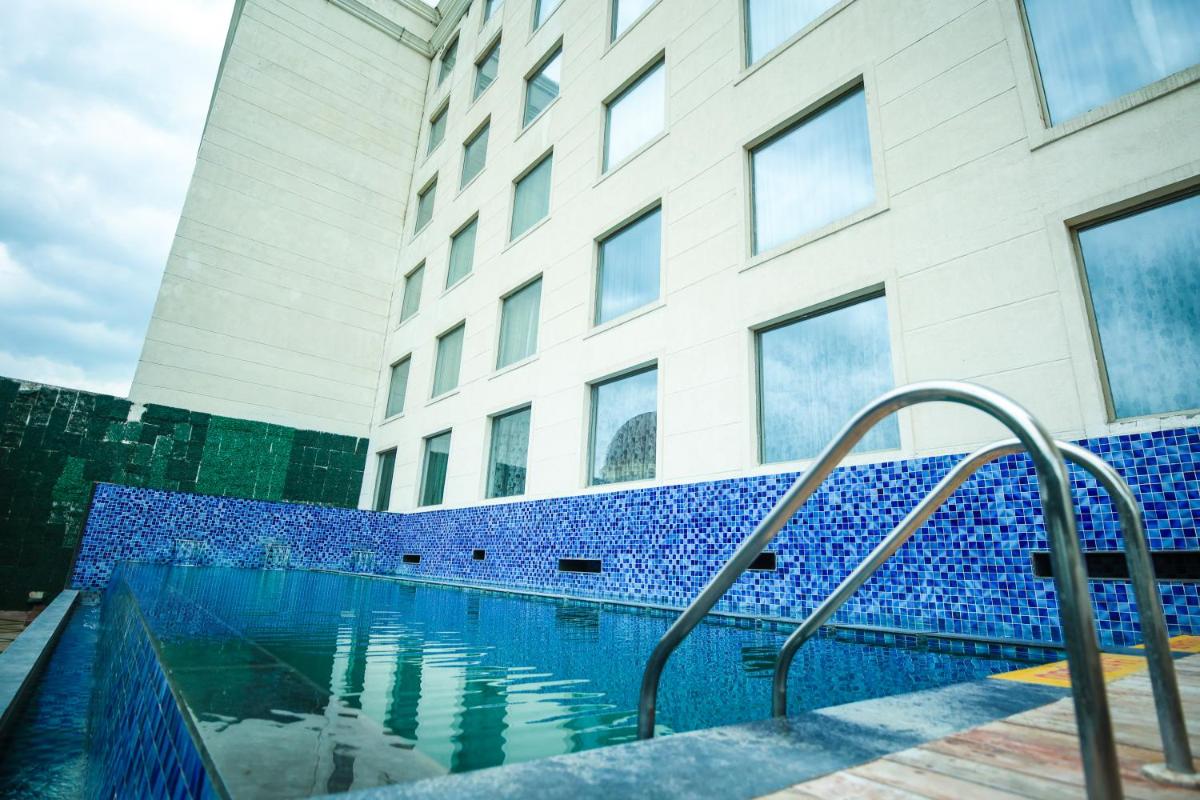 a swimming pool in front of a building at Ramada Plaza by Wyndham Lucknow in Lucknow