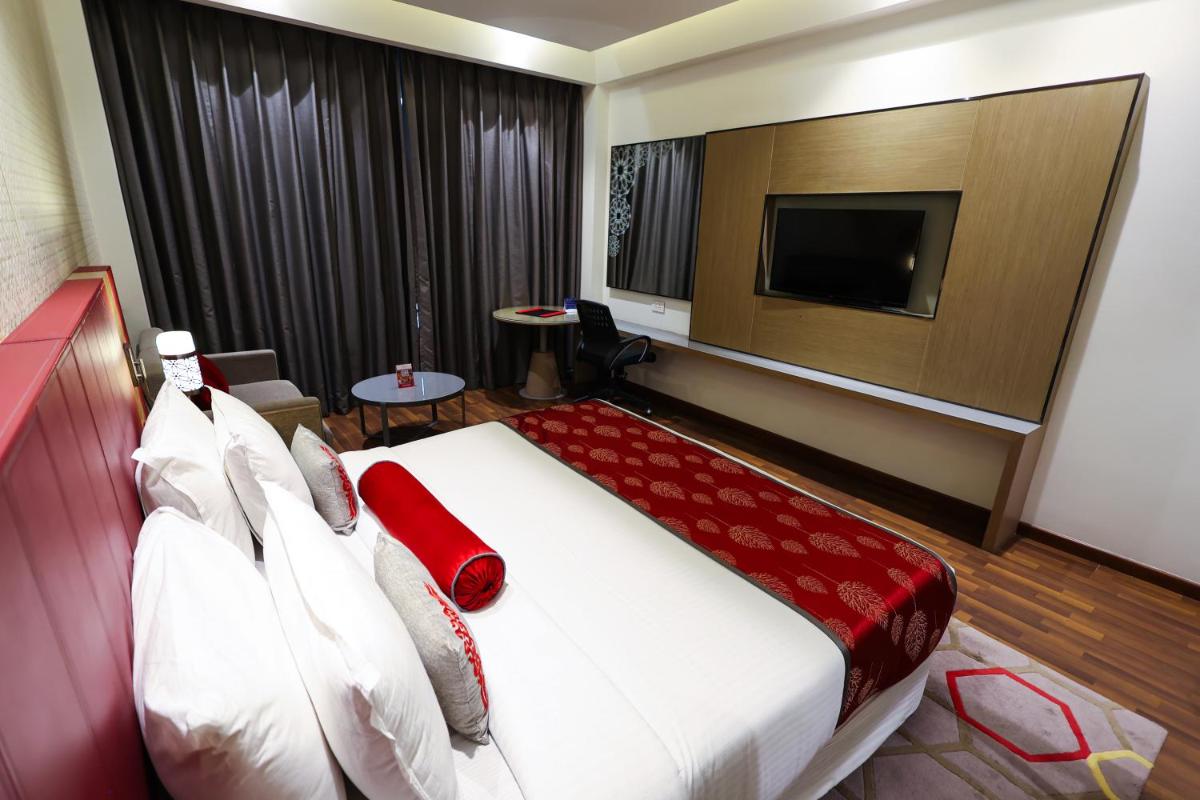 a hotel room with a bed and a tv at Ramada Plaza by Wyndham Lucknow in Lucknow