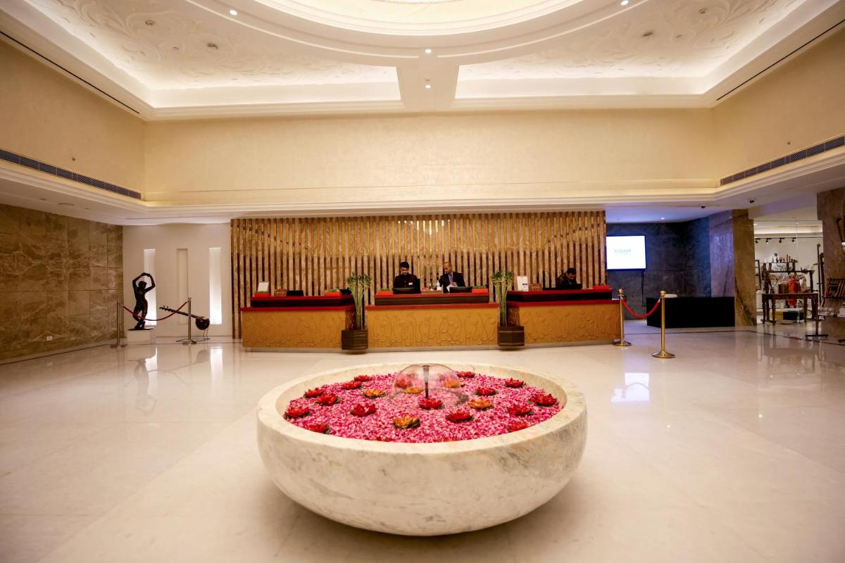 a large bowl filled with pink flowers in a lobby at Ramada Plaza by Wyndham Lucknow in Lucknow
