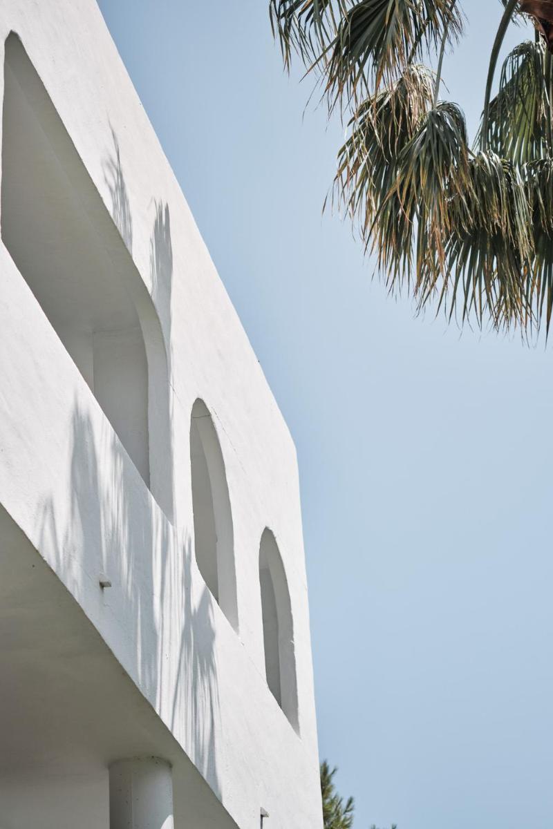 Un edificio blanco con ventanas y una palmera. en Prinsotel Alba & Spa, en Cala d´Or 124 fotos más