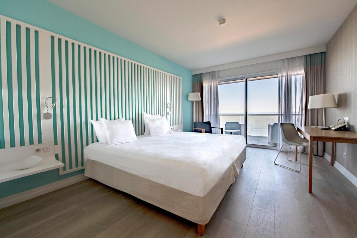 une chambre avec un lit, un bureau et un lavabo dans l'établissement Radisson Blu Resort & Spa, Ajaccio Bay, à Porticcio
