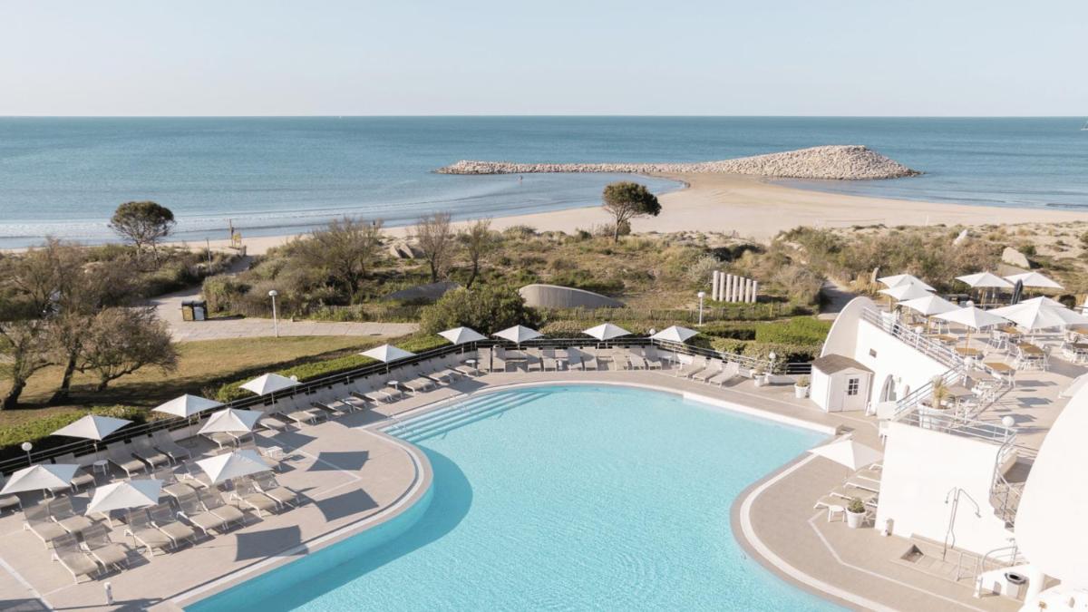 une vue aérienne d'un complexe hôtelier avec piscine et plage dans l'établissement Hôtel Les Corallines - Thalasso & Resort, à La Grande Motte