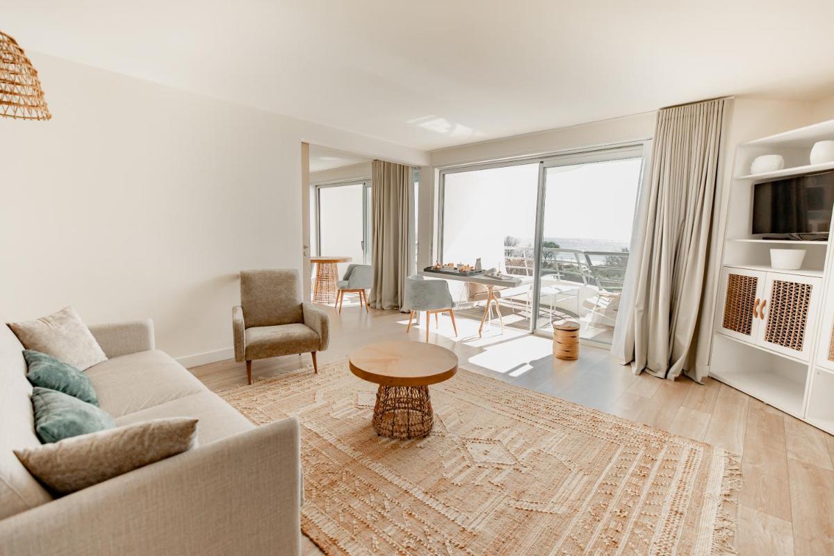un salon avec un canapé et une table dans l'établissement Hôtel Les Corallines - Thalasso & Resort, à La Grande Motte
