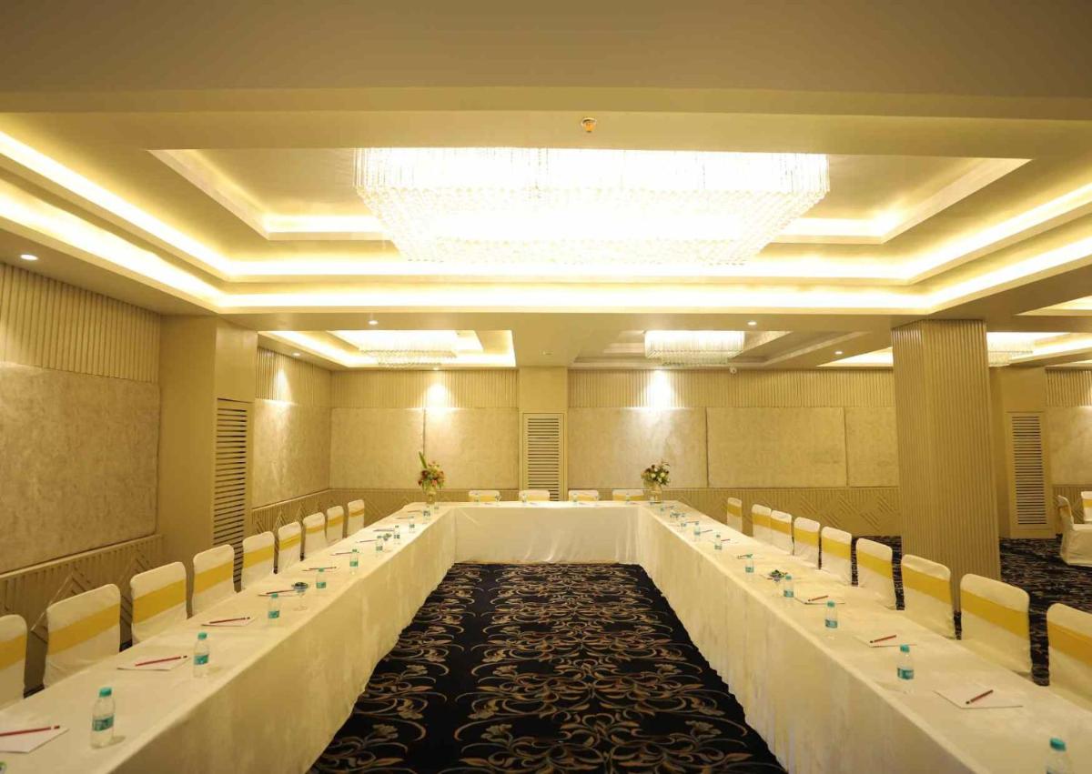a large banquet hall with long tables and chairs at Essentia Luxury Resort & Spa Udaipur in Udaipur