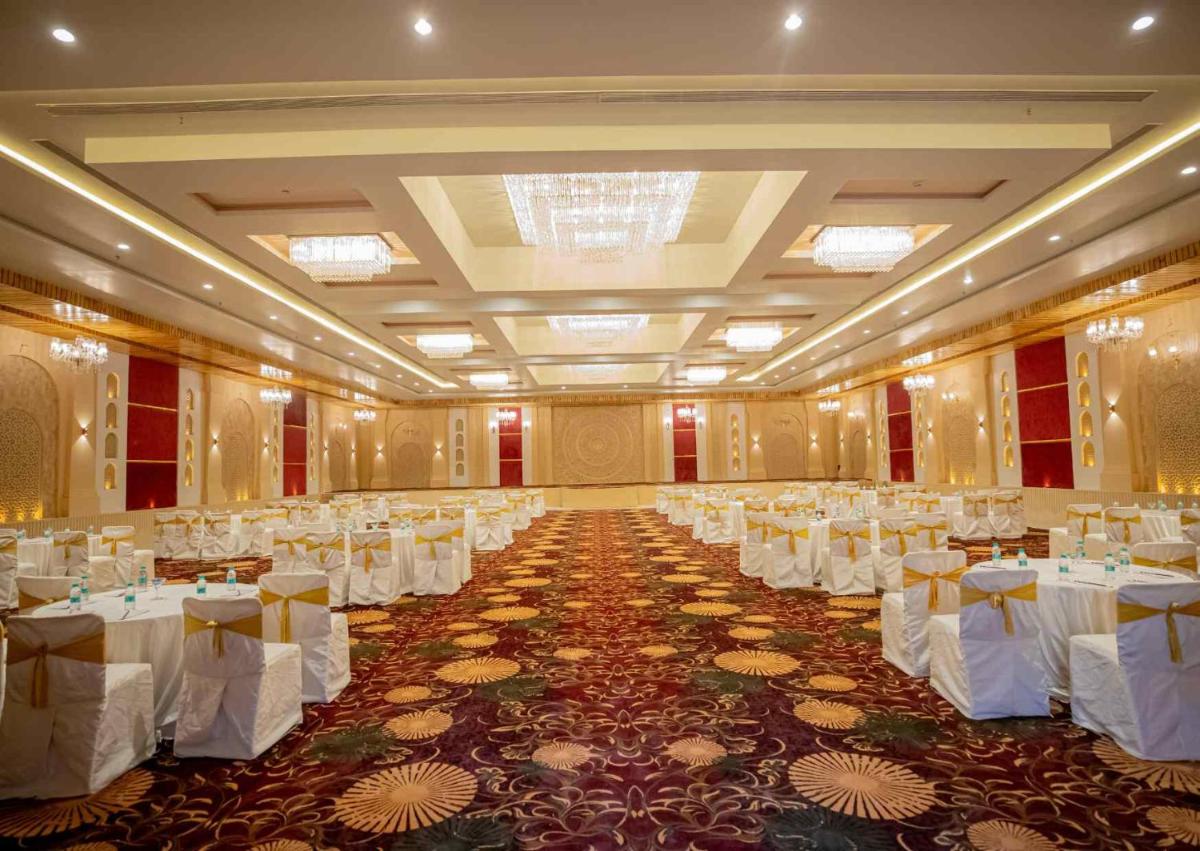 a large banquet hall with white tables and chairs at Essentia Luxury Resort & Spa Udaipur in Udaipur