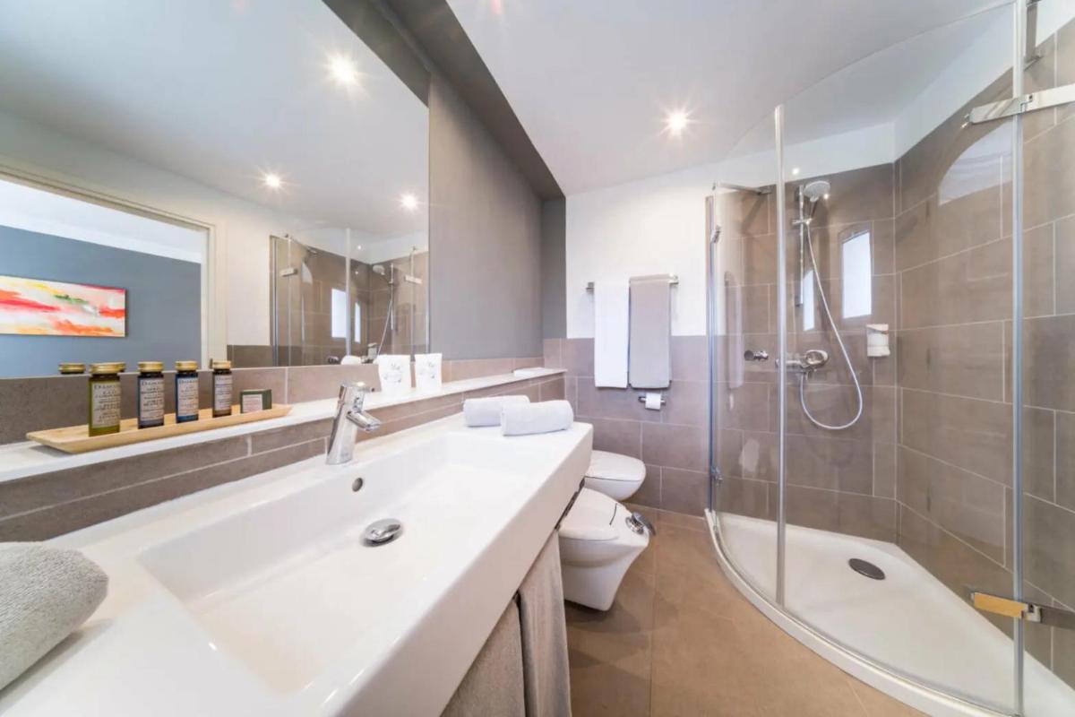 Un baño con lavabo, ducha e inodoro. en OCEANO Health Spa Hotel, en Punta del Hidalgo