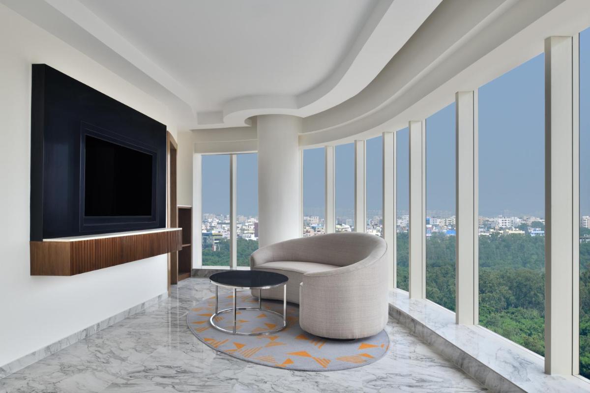a living room with a chair and a television at Le Meridien Hyderabad in Hyderabad
