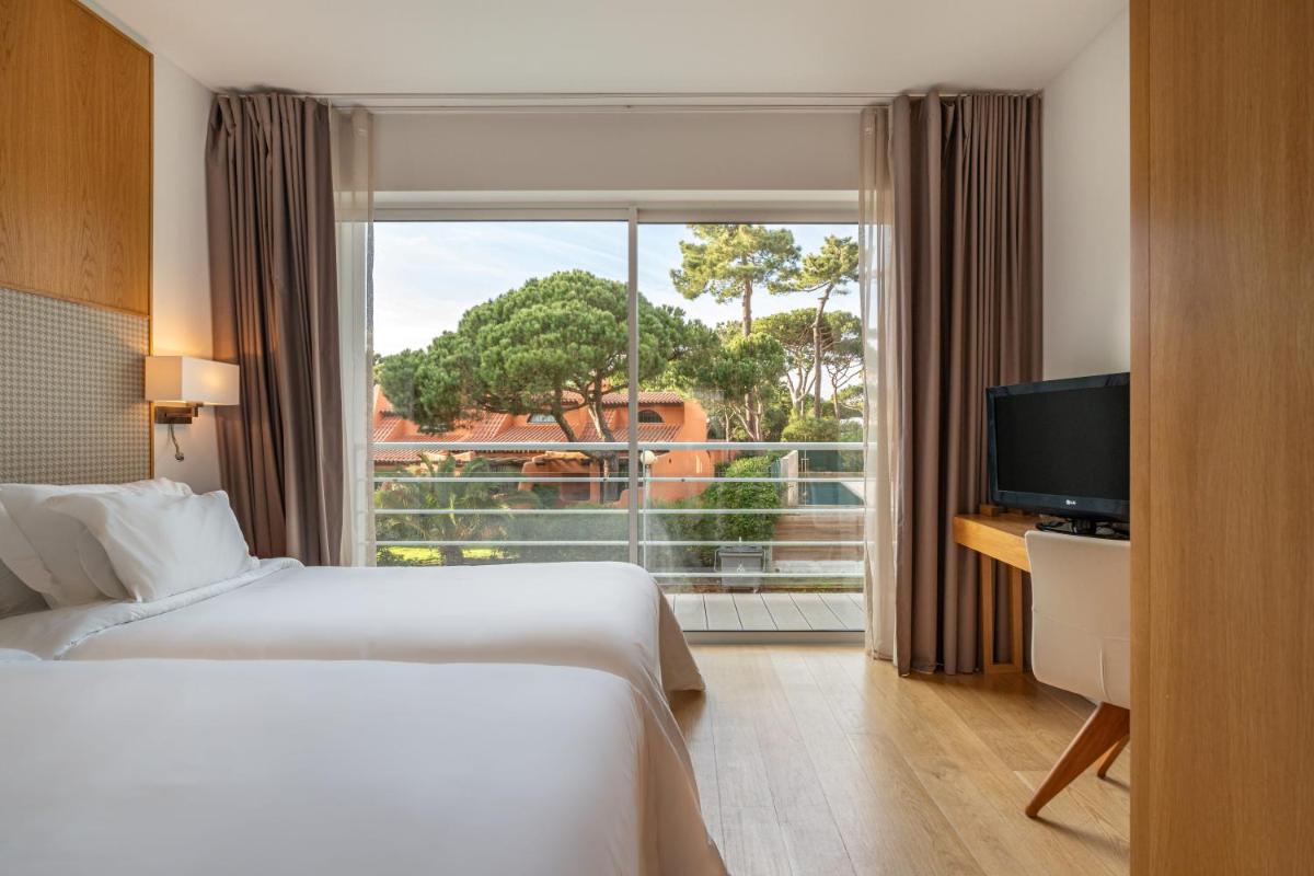 Uma cama ou camas num quarto em Onyria Marinha Cascais, Vignette Collection by IHG