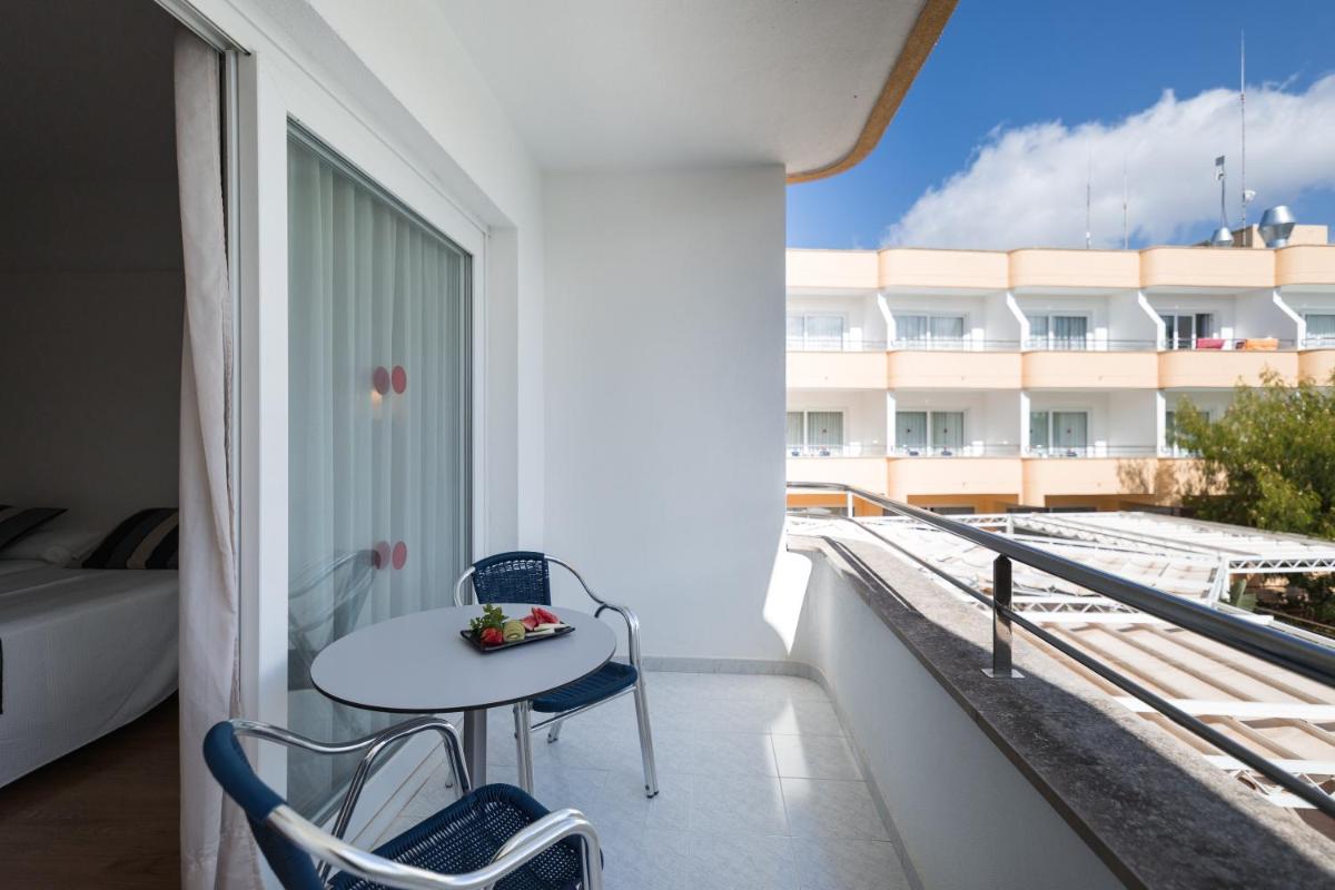 Un balcón con una mesa y vista a un edificio. en Sagitario Playa, en Cala Blanca