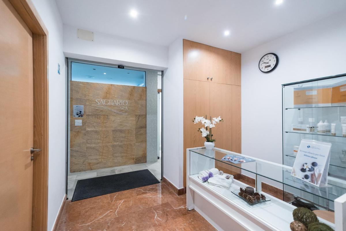 baño con ducha y reloj en la pared en Sagitario Playa, en Cala Blanca