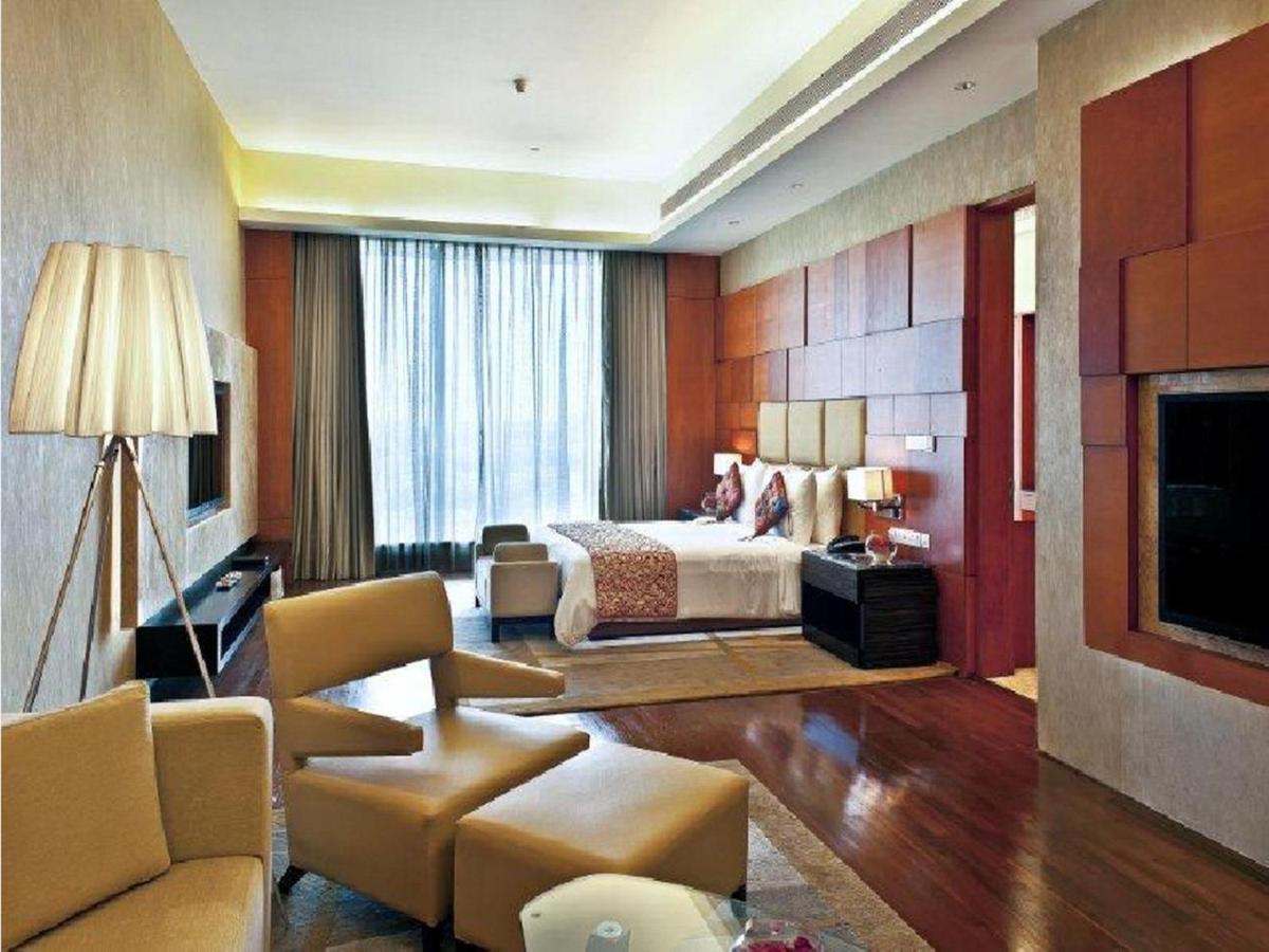 a hotel room with a bed and a living room at Gokulam Grand Hotel & Spa Bangalore in Bengaluru a hotel room with a bed and a living room at Gokulam Grand Hotel & Spa Bangalore in Bengaluru