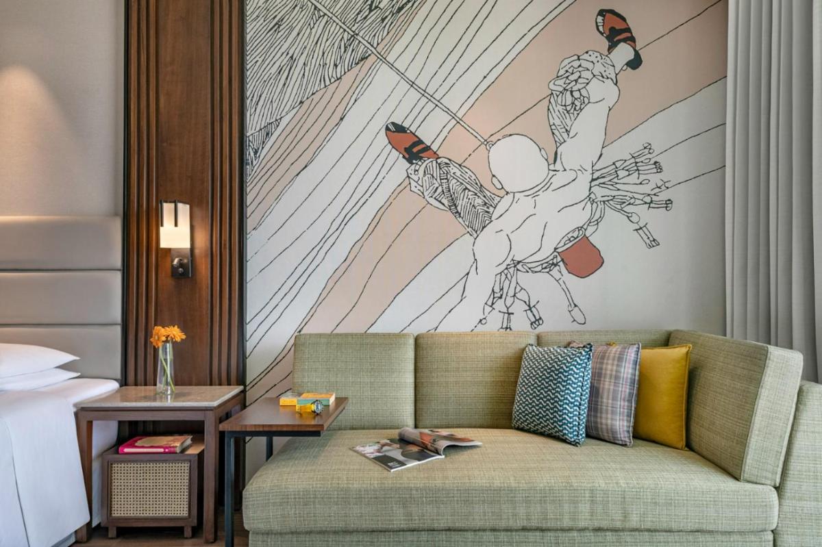 a living room with a couch with a painting on the wall at Hyatt Centric Rajpur Road Dehradun in Dehradun