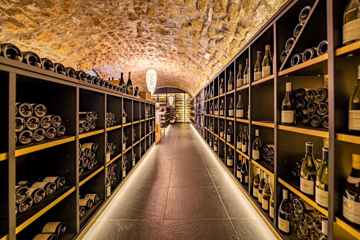 une salle remplie de nombreuses bouteilles de vin dans l'établissement Domaine de la Klauss & Spa, Restaurant Gastronomique Le K, à Montenach