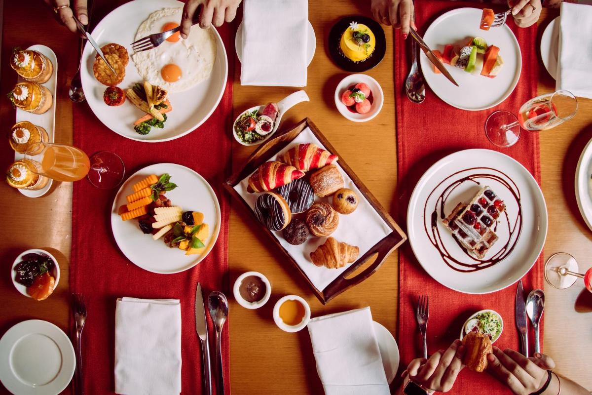 a table with plates of food on it at Novotel New Delhi Aerocity in New Delhi