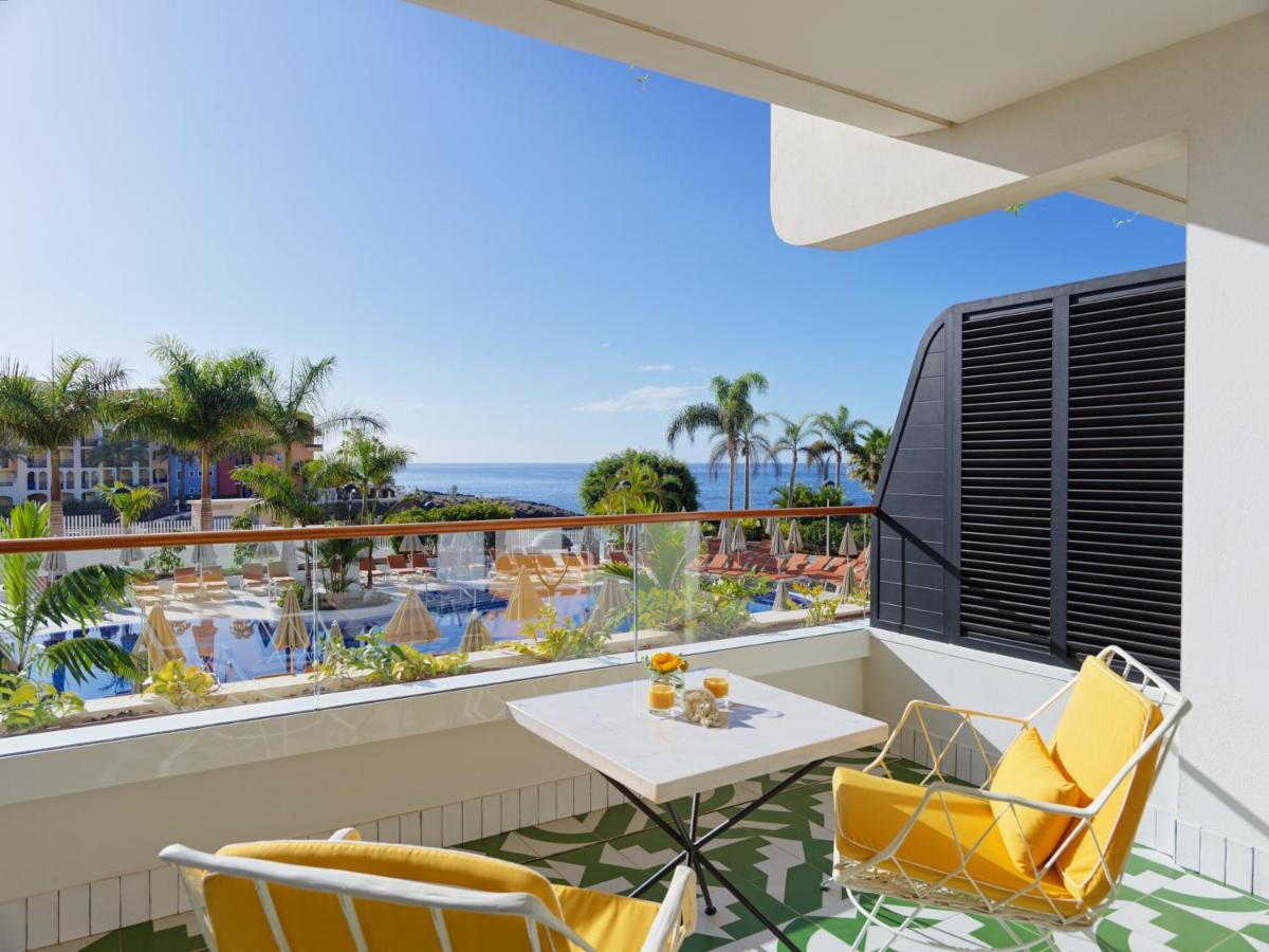 Un balcón con mesa y sillas y vista al mar. en H10 Atlantic Sunset Horizons Collection, en Adeje