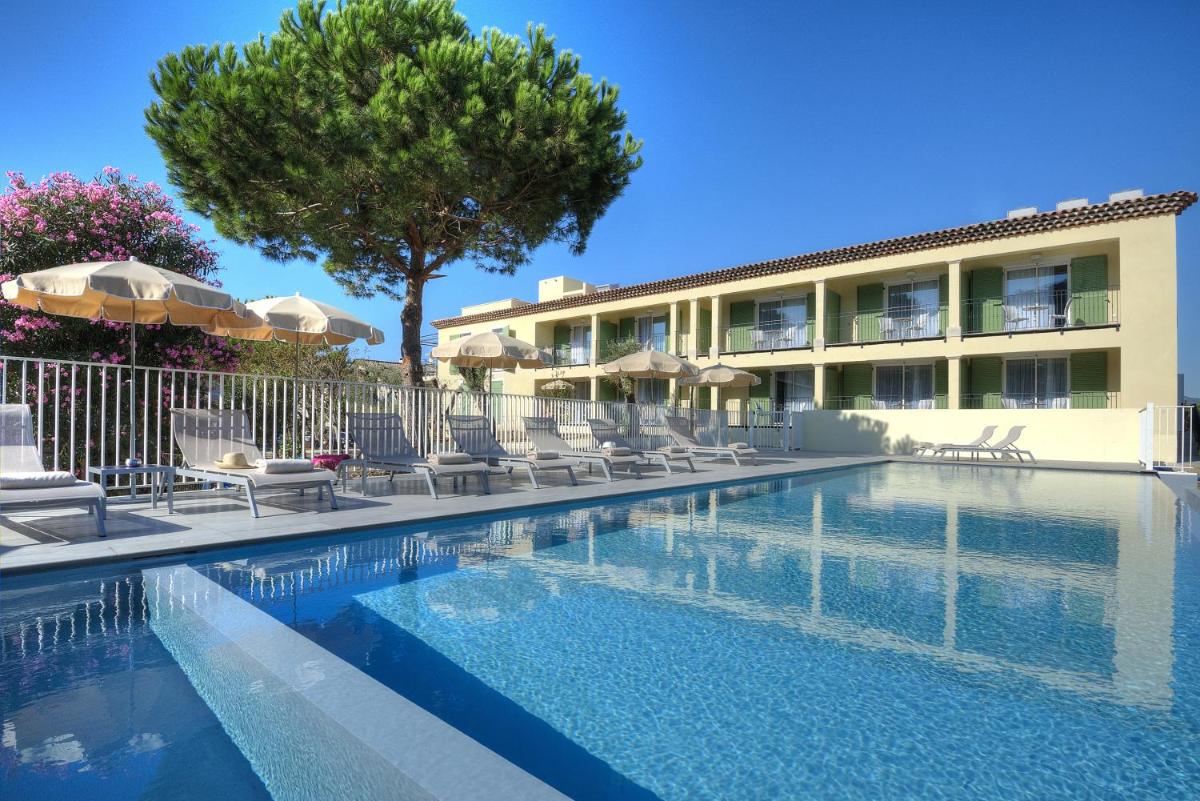une piscine devant un hôtel avec chaises et parasols dans l'établissement La Bastide de l'Oliveraie, à Cannes
