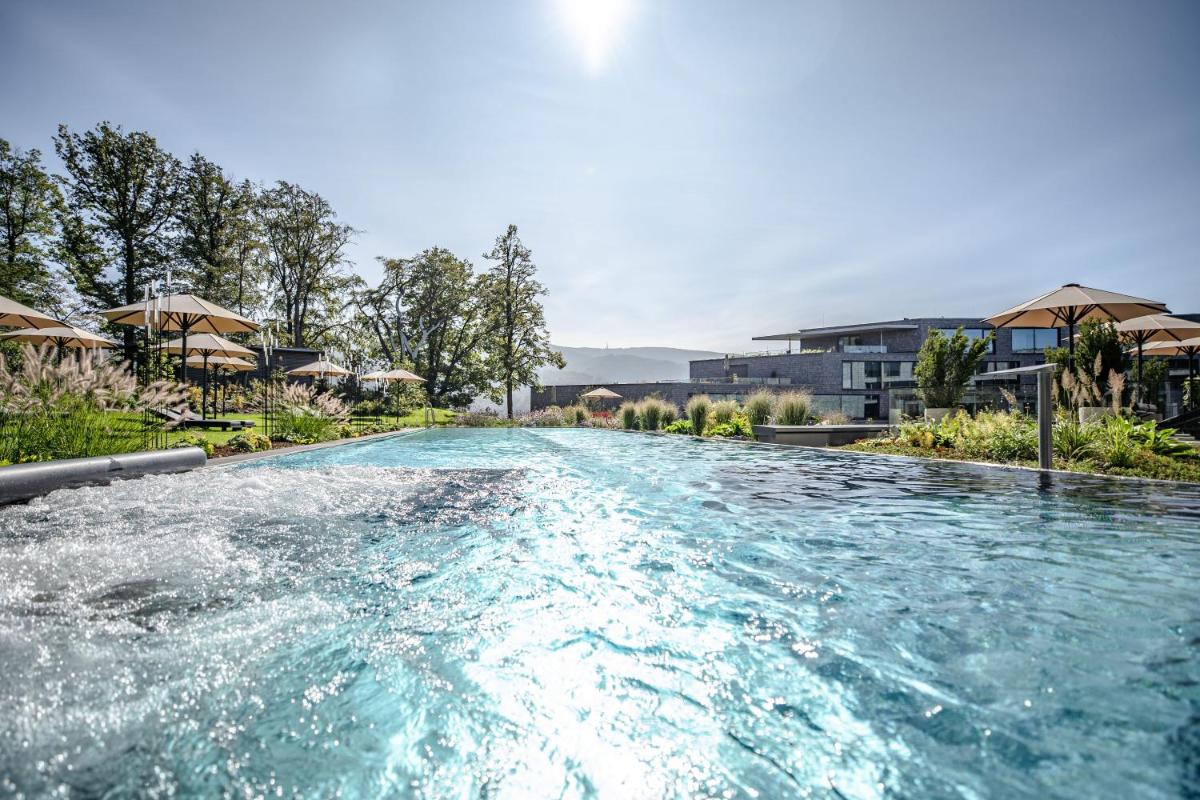 einen Pool mit blauem Wasser in einem Resort in der Unterkunft Luisenhöhe - Gesundheitsresort Schwarzwald in Horben + 34 Fotos