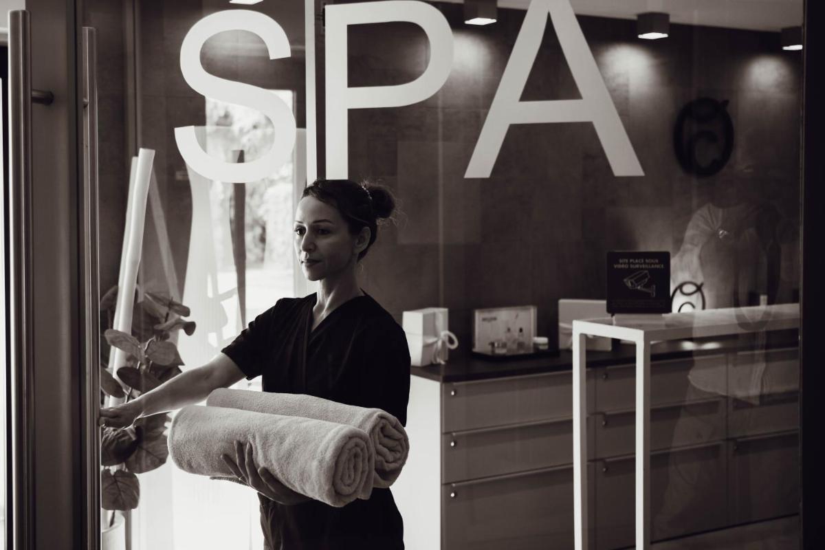 une femme tenant une pile de serviettes dans la vitrine d'un magasin dans l'établissement Du Côté Des Olivades, à Paradou
