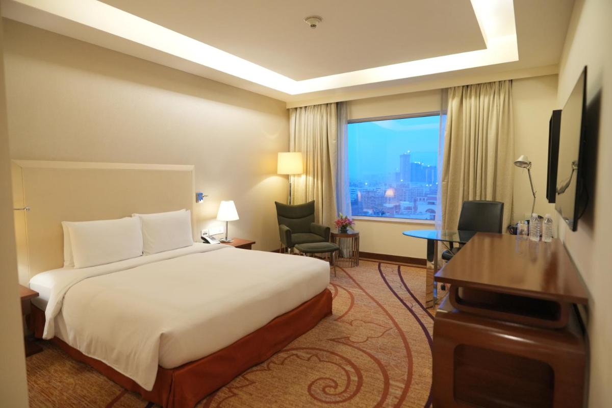 a hotel room with a bed and a desk and a window at DoubleTree by Hilton Gurgaon New Delhi NCR in Gurgaon