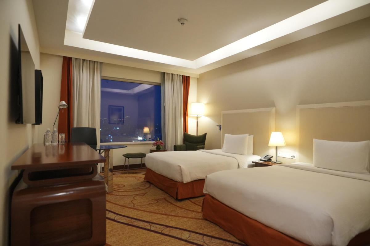 a hotel room with two beds and a desk at DoubleTree by Hilton Gurgaon New Delhi NCR in Gurgaon