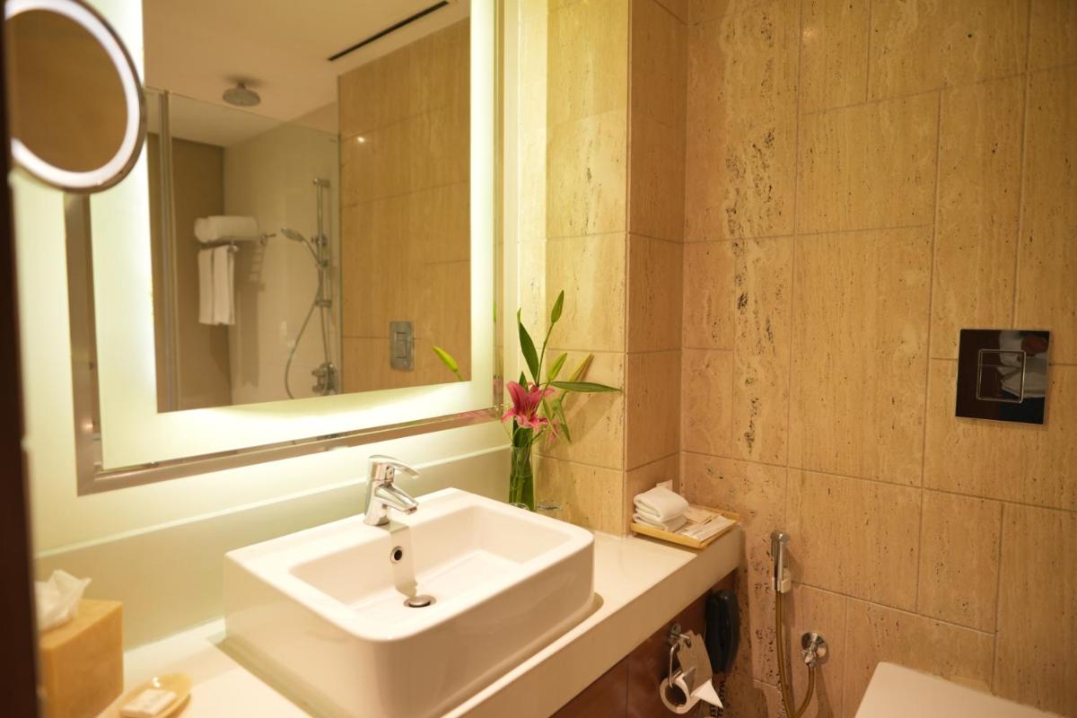 a bathroom with a sink and a mirror at DoubleTree by Hilton Gurgaon New Delhi NCR in Gurgaon