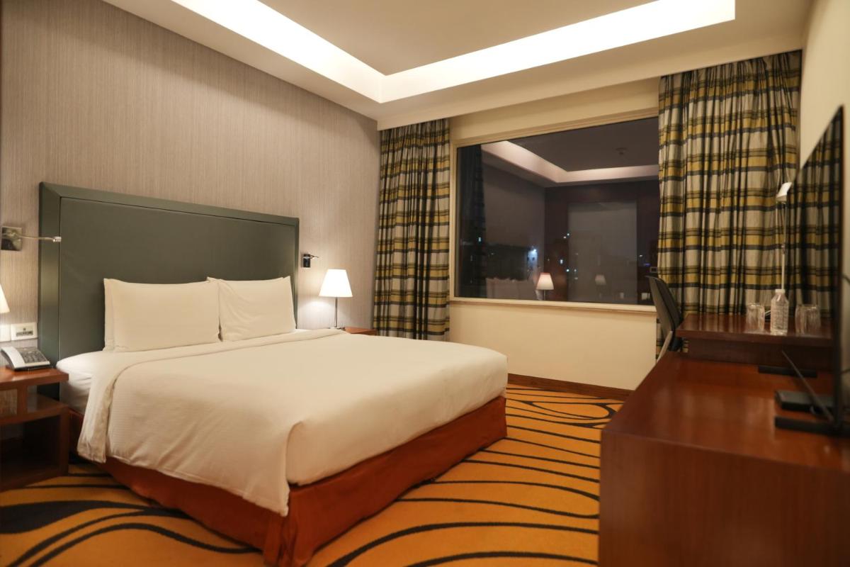 a hotel room with a bed and a window at DoubleTree by Hilton Gurgaon New Delhi NCR in Gurgaon