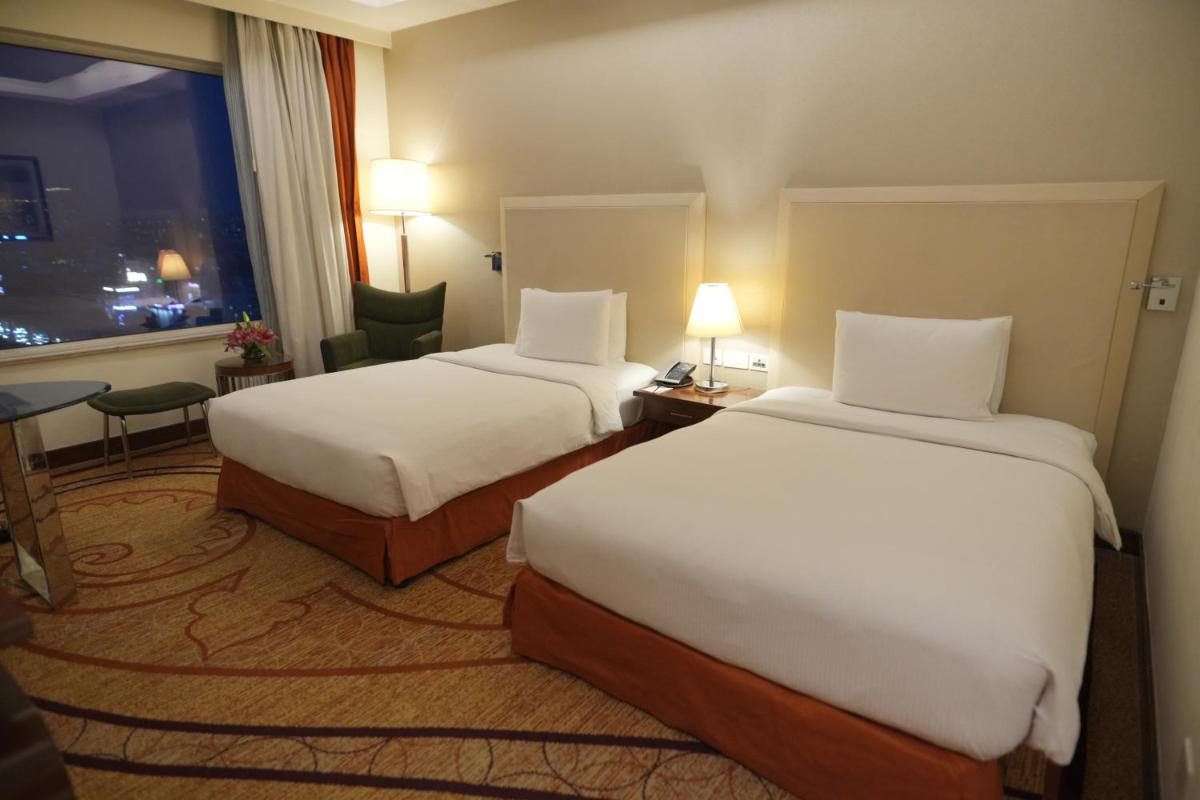 a hotel room with two beds and a window at DoubleTree by Hilton Gurgaon New Delhi NCR in Gurgaon