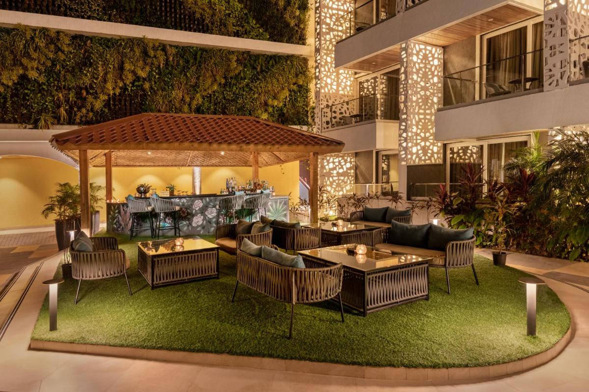 a restaurant with tables and chairs in a building at Hyatt Place Goa Candolim in Candolim a restaurant with tables and chairs in a building at Hyatt Place Goa Candolim in Candolim